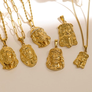 Detailed close-up of golden Jesus Christ head pendants with sparkling inlaid gemstones