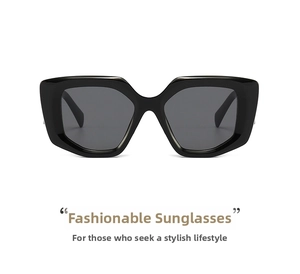 Detail view of bold oversized geometric sunglasses with glossy black frames and dark lenses
