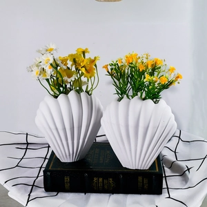 Detail of shell-shaped silicone mold crafts with daisy flowers on vintage books