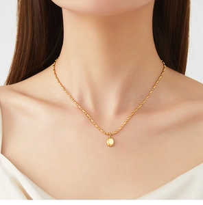 Vue détaillée d'un pendentif ovale plaqué or 18K sur une chaîne à billes sur mannequin