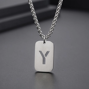 Vue macro d'un pendentif rectangulaire en argent brossé avec lettre Y ajourée