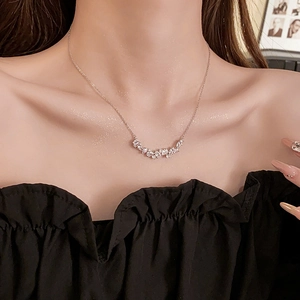 Detail of silver wheat ear necklace with cubic zirconia worn on female collarbone