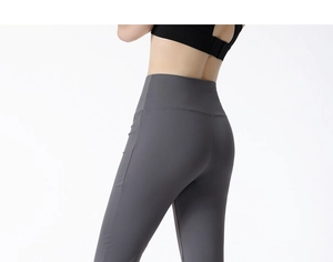 Detail of high-waist flared yoga pants in dark grey with slimming crossover waistband