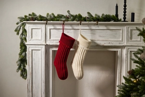 Close-up of red and beige knit Christmas stockings hanging on a rustic mantelpiece