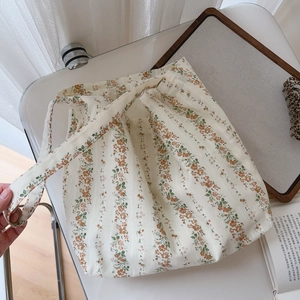 Close-up of floral cotton shoulder bag with orange flower patterns on a white background