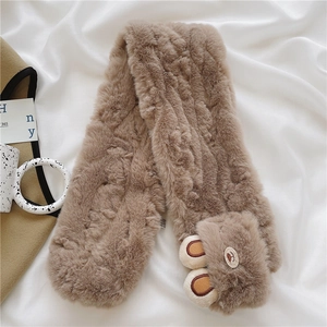 Close-up of soft camel plush scarf with cute 3D bear ears on a silk background