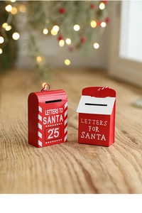 Close-up of red painted metal Christmas mailboxes on wood with festive bokeh background