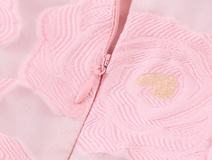 Détail du tissu jacquard rose à motif de roses avec fermeture éclair et cœur doré