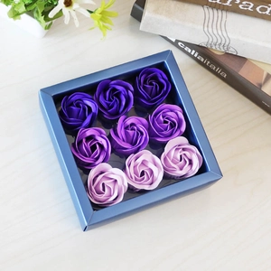 Detail of 9 purple gradient soap roses in a blue square gift box on a wooden desk