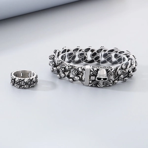 Macro view of vintage stainless steel skull bracelet and ring set for men in silver