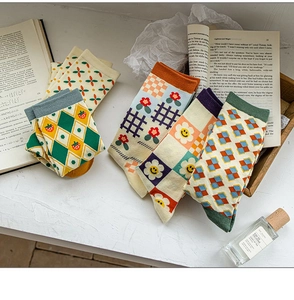 Detail of vintage patterned crew socks with argyle and floral motifs on a desk