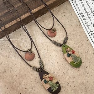 Detailed view of Bohemian style waterdrop necklace with retro bow charm and ethnic tassel