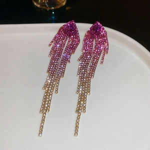 Macro detail of cascading rhinestone fringe earrings with rose red to champagne gradient