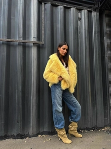 Fashionable bright yellow faux fur coat with oversized collar and plush texture for winter