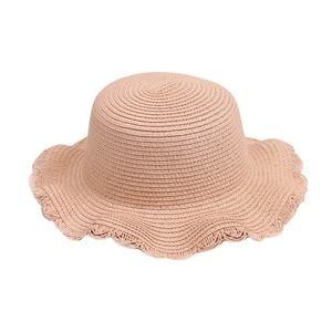 Cappello da sole in paglia intrecciata rosa da donna con tesa ondulata su sfondo bianco