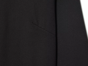Gros plan sur robe midi noire montrant la texture du sergé et les détails de couture