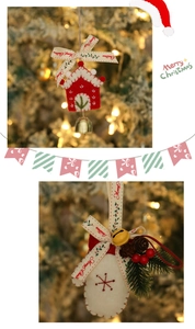 Detail of Christmas felt house with golden bells and pine needle decorated gloves