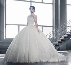 Détail de robe de mariée à col montant avec manches longues en dentelle transparente