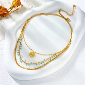 Three-layer gold titanium necklace featuring sunburst pendant and blue bead accents