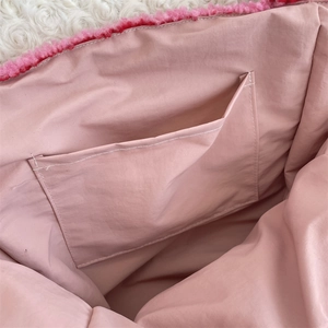 Macro view of the pink fabric lining and internal storage pocket of the dog pattern bag