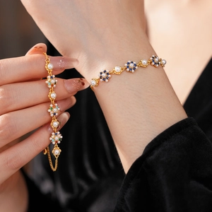 Detailed shot of vintage gold flower bracelet with pearls and colored zircon stones