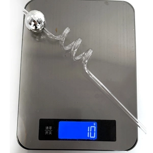 Detailed view of disco mirror ball straw weighing 10g on a digital scale for parties