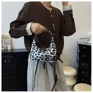 Close-up of leopard print patent leather handbag with metal zippers and sleek handle