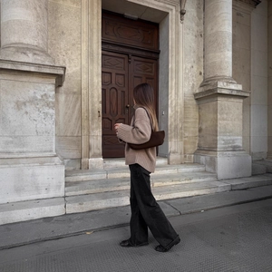 Chic beige turtleneck knit sweater paired with black wide-leg jeans in classic urban setting