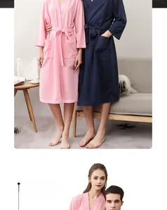 Detail of couple's waffle bathrobe in pink and navy blue with absorbent textured fabric