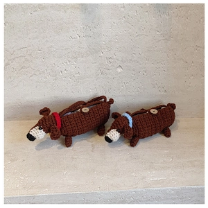 Detaillierte Stricktextur handgefertigter Dackel-Taschen mit Holzknöpfen und bunten Halsbändern