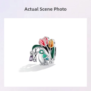 Detail of S925 silver bird and tulip charm with enamel finish and purple gemstone