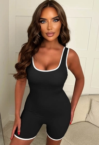 Detail of black sporty romper featuring white contrast binding and wide round neckline