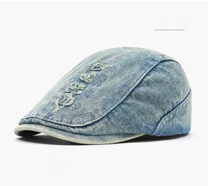 Close-up of blue washed denim flat cap with vintage embroidery and fabric texture