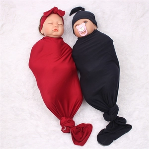 Newborn baby swaddle blanket set with matching bow headband and knotted hat in red and black