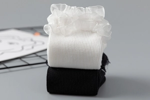 Détail de chaussettes en tricot côtelé blanc et noir avec bordure en dentelle d'organza