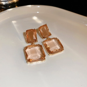 Detailed macro view of amber crystal geometric earrings in gold claw setting