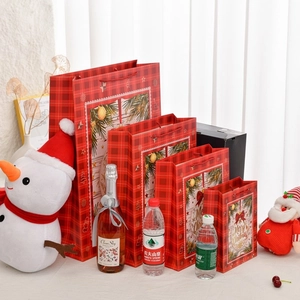Set of four red plaid Christmas gift bags with handles in various sizes for apple packaging