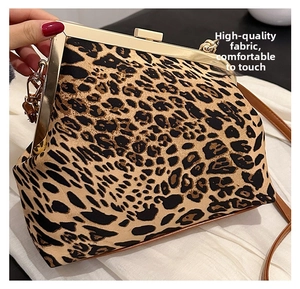 Detail of leopard print shell bag with gold metal frame and brown leather strap