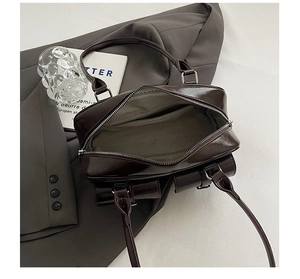 Top view detail of large coffee brown bowling bag with silver buckles and spacious interior