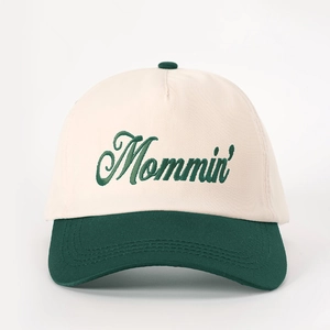 Two-tone beige and forest green baseball cap featuring Mommin' embroidered script