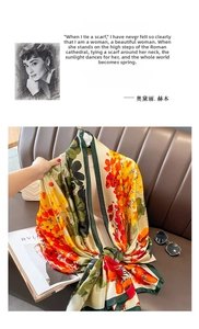 Detailed view of a vintage floral silk-like shawl with green border on a leather sofa