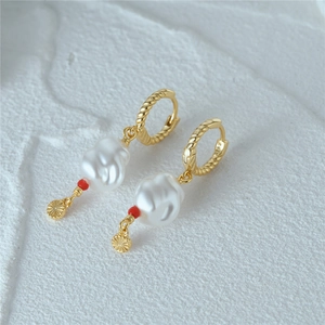 Detailed macro view showing the S925 hallmark on the golden twisted pearl hoop earring