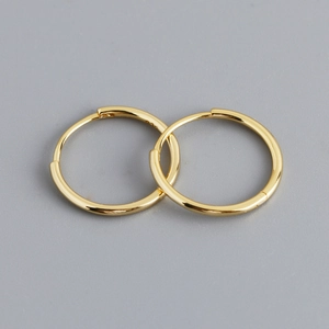 Macro view of 925 sterling silver stamp on minimalist gold-plated hoop earrings