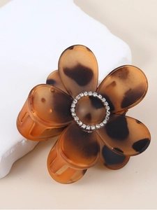 Detailed view of amber leopard print flower hair claw with sparkling rhinestones