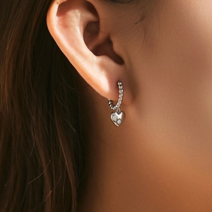 Elegant S925 silver hoop earrings with a sparkling heart pendant worn on ear