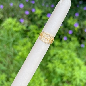 Detailed macro view of 18K gold-plated feather ring with sparkling zircon micro-pave setting
