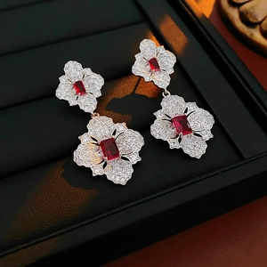 Close-up of luxury flower earrings with red rubies and diamonds in black gift box