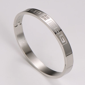 Detailed 45-degree view of silver stainless steel bangle with Greek key pattern and zircons