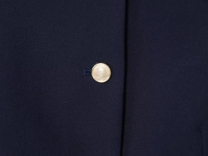 Gros plan du tissu bleu foncé et des boutons métalliques dorés sur le short