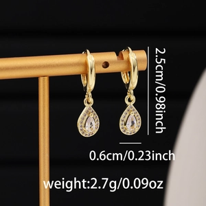 Detail of gold huggie hoop earrings with pear-cut cubic zirconia and size dimensions